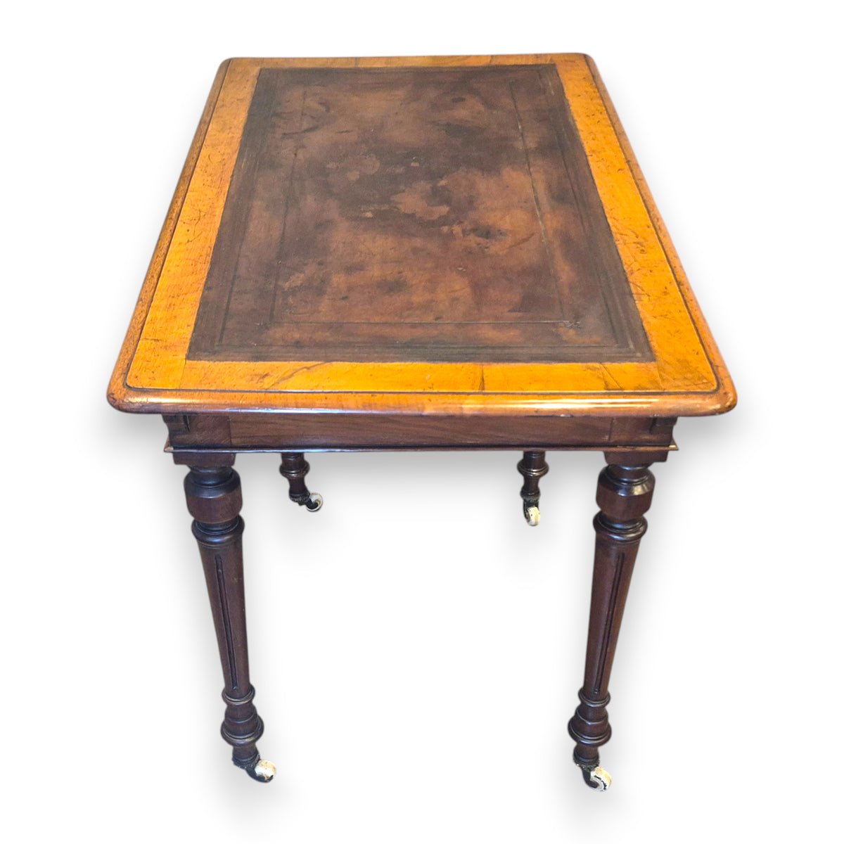Victorian leather top writing table shown from three-quarter angle