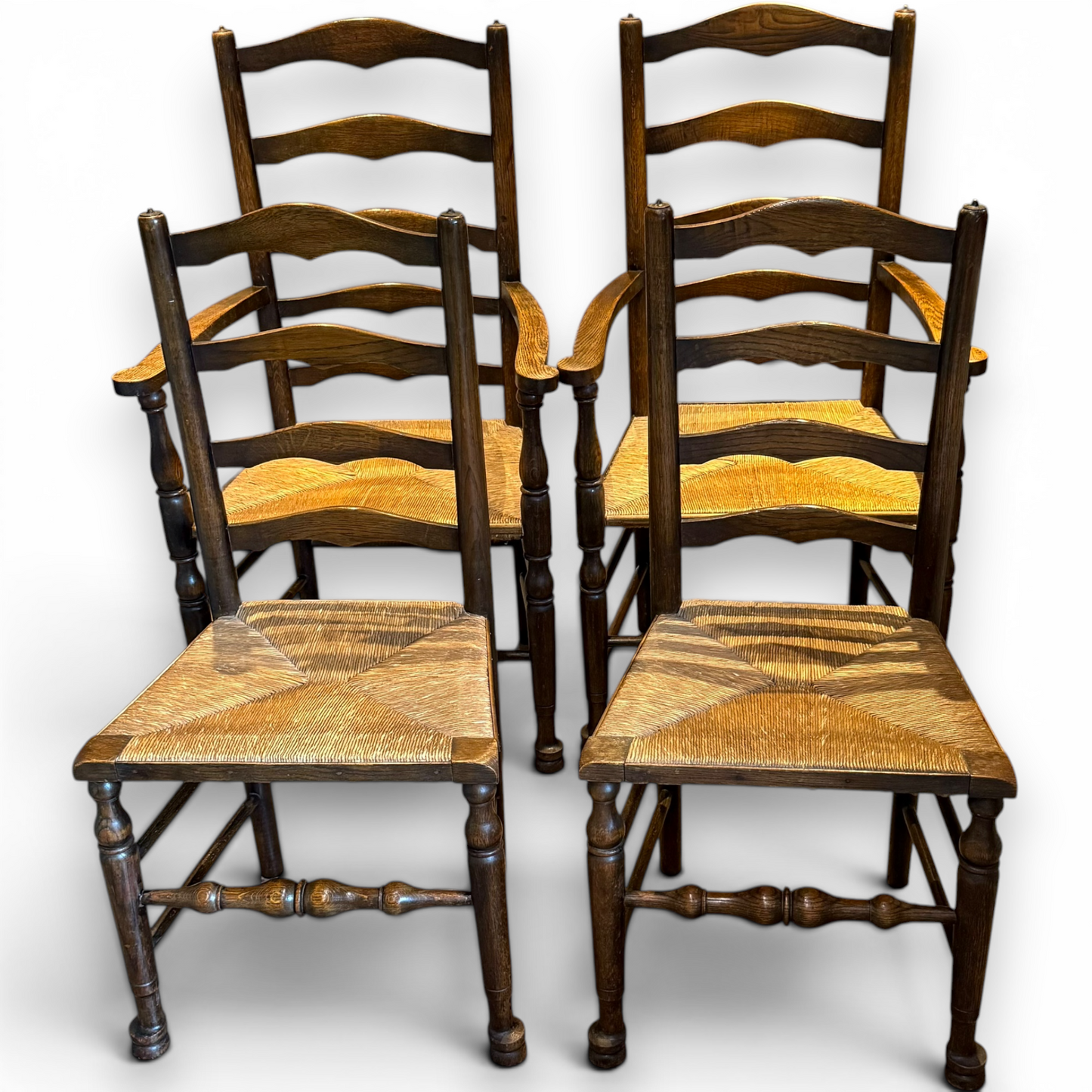 A delightful set of four Early 20th Century Oak Ladder Back Dining Chairs, comprising a matching pair of Oak Carver Chairs and two Side Chairs.