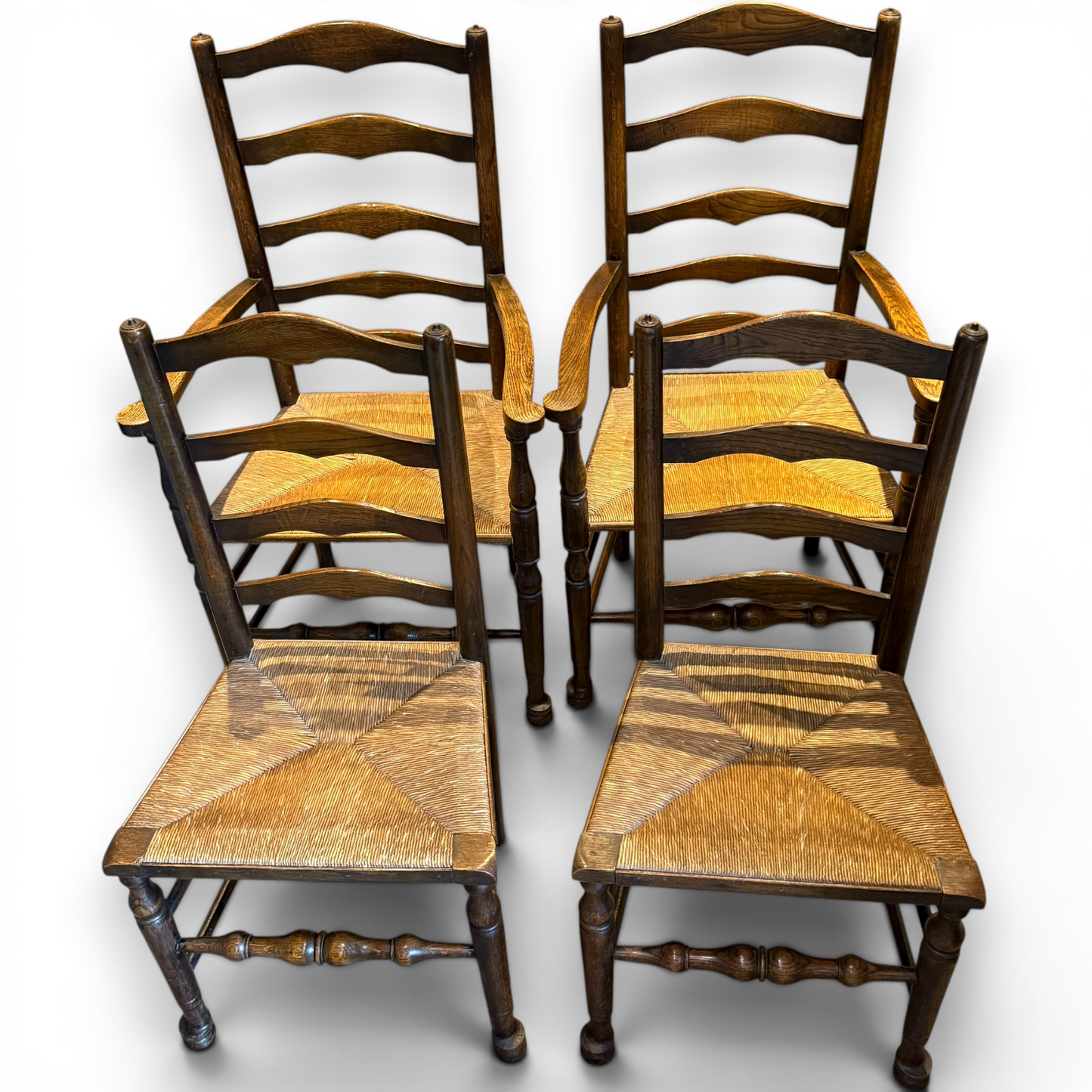 A delightful set of four Early 20th Century Oak Ladder Back Dining Chairs, comprising a matching pair of Oak Carver Chairs and two Side Chairs.