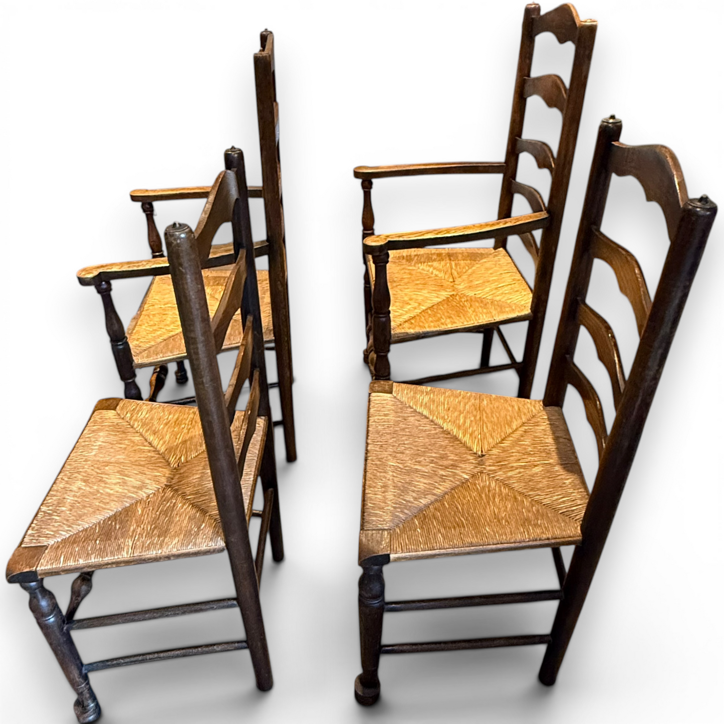 A delightful set of four Early 20th Century Oak Ladder Back Dining Chairs, comprising a matching pair of Oak Carver Chairs and two Side Chairs.
