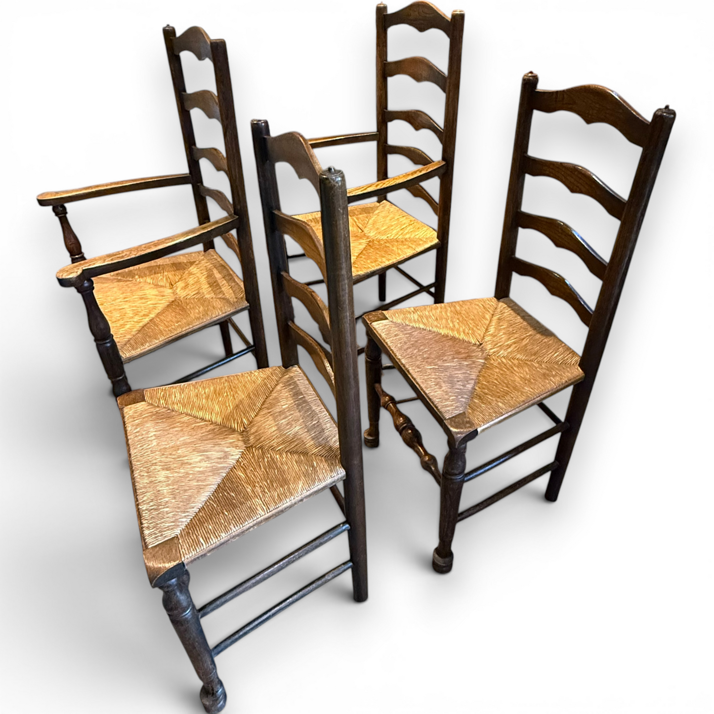 A delightful set of four Early 20th Century Oak Ladder Back Dining Chairs, comprising a matching pair of Oak Carver Chairs and two Side Chairs.
