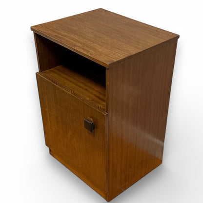 Angled view of Mid century Remploy teak bedside cabinet with open shelf and cupboard