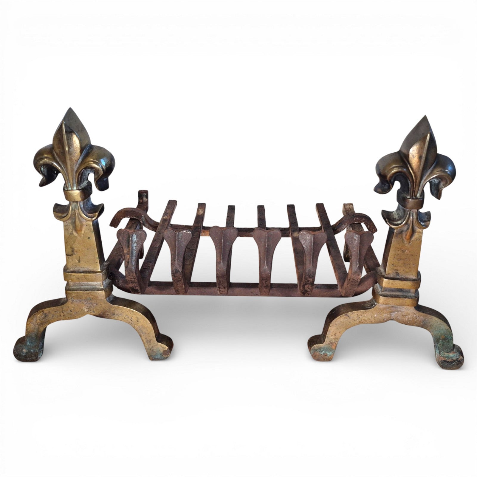 Antique brass and iron fire grate with fleur-de-lis finials