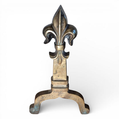 Detail of brass fleur-de-lis finial on antique fire grate