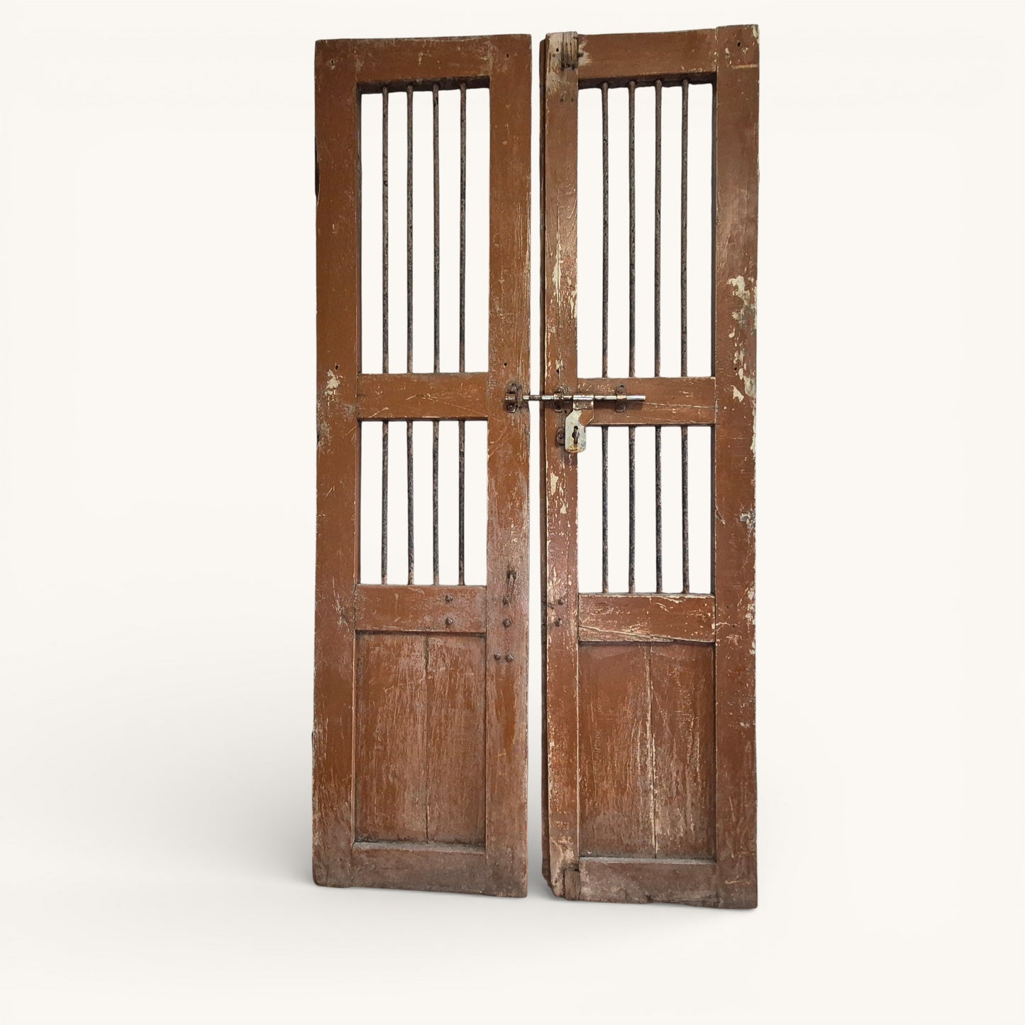 Pair of antique Indian jali doors with vertical iron bars and aged timber frames, reclaimed architectural salvage panels.