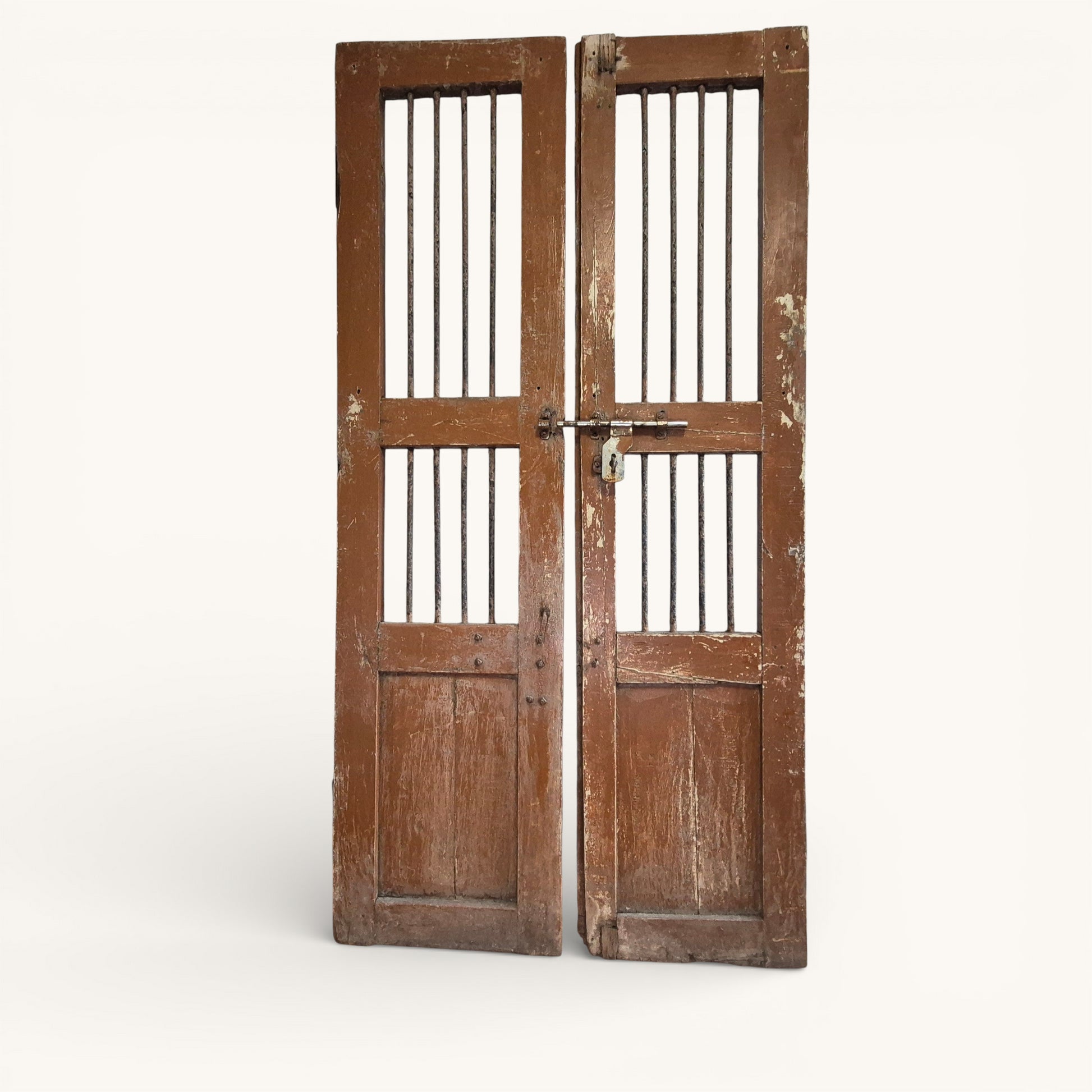 Pair of antique Indian jali doors with vertical iron bars and aged timber frames, reclaimed architectural salvage panels.