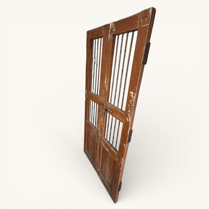 Right hand side view of antique Indian wooden jali doors showing iron bar panels, original bolt fastening and rustic aged patina.