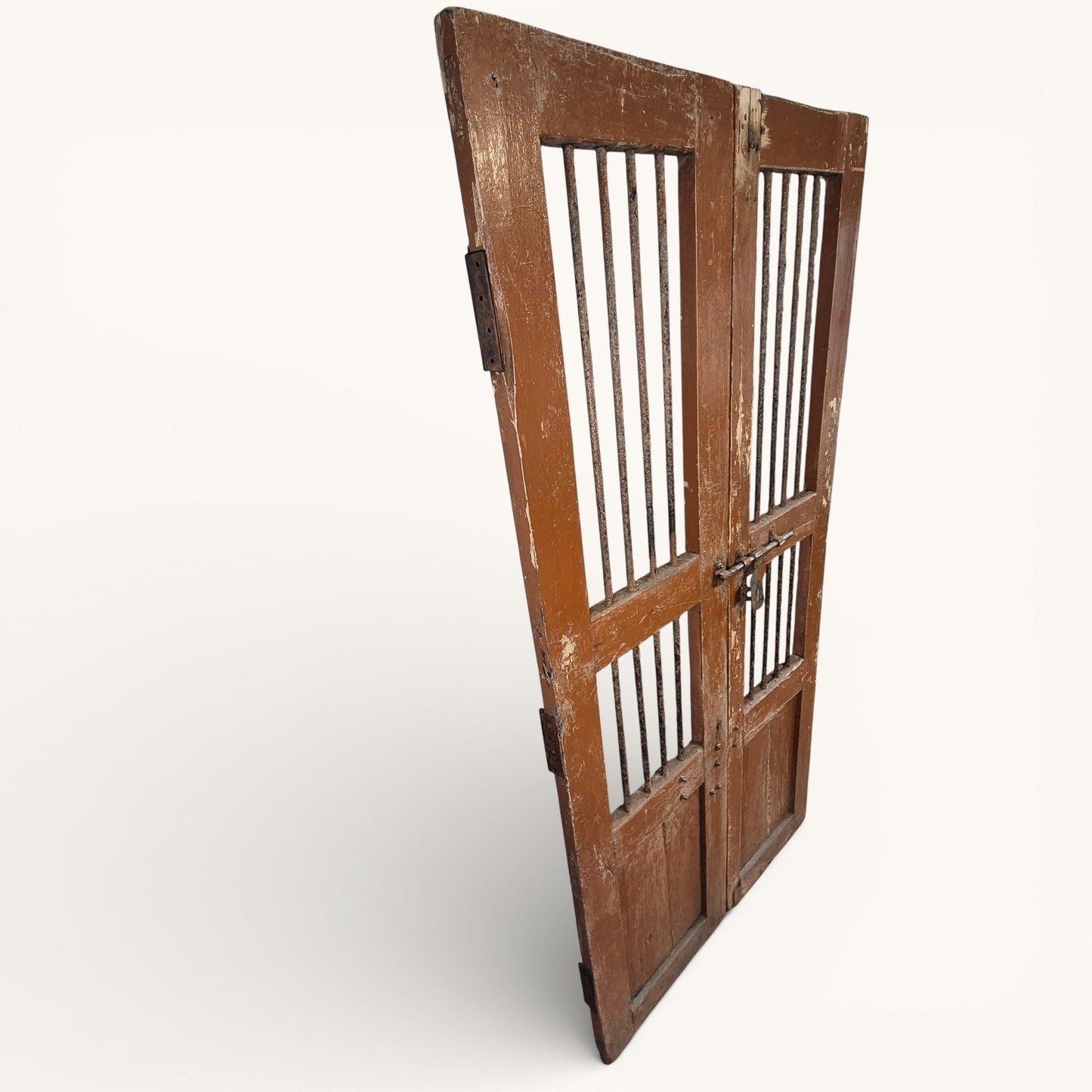 Side view of antique Indian wooden jali doors showing iron bar panels, original bolt fastening and rustic aged patina.
