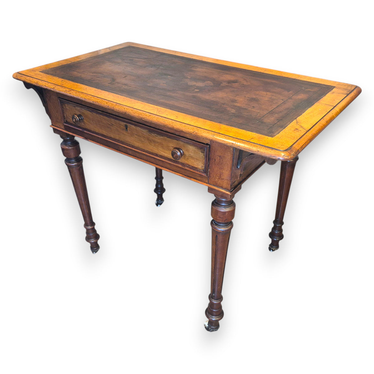 Antique Victorian leather top writing table shown from three-quarter angle