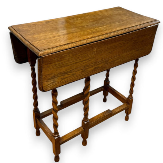 Front view of antique oak gateleg table with barley twist legs and drop-leaf top