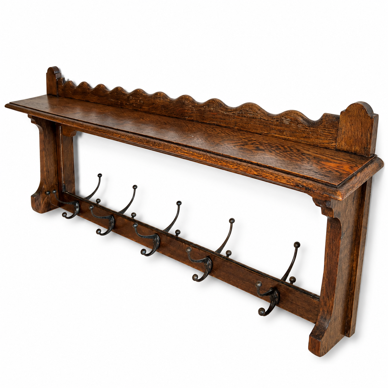 Decorative scalloped top shelf on antique oak wall mounted coat rack