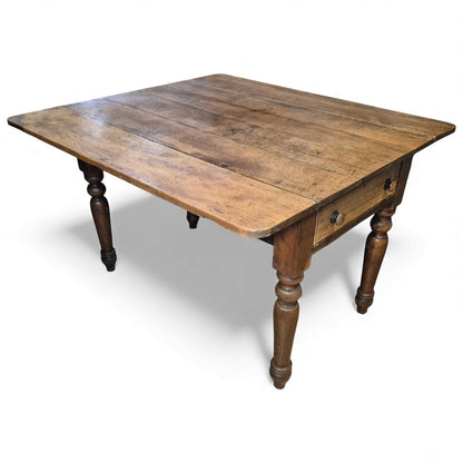 Rustic oak drop-leaf table showing early plank top and Victorian legs