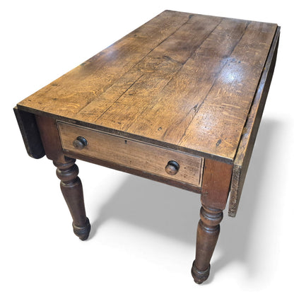 Antique oak farmhouse kitchen table with plank top and drop-leaf sides