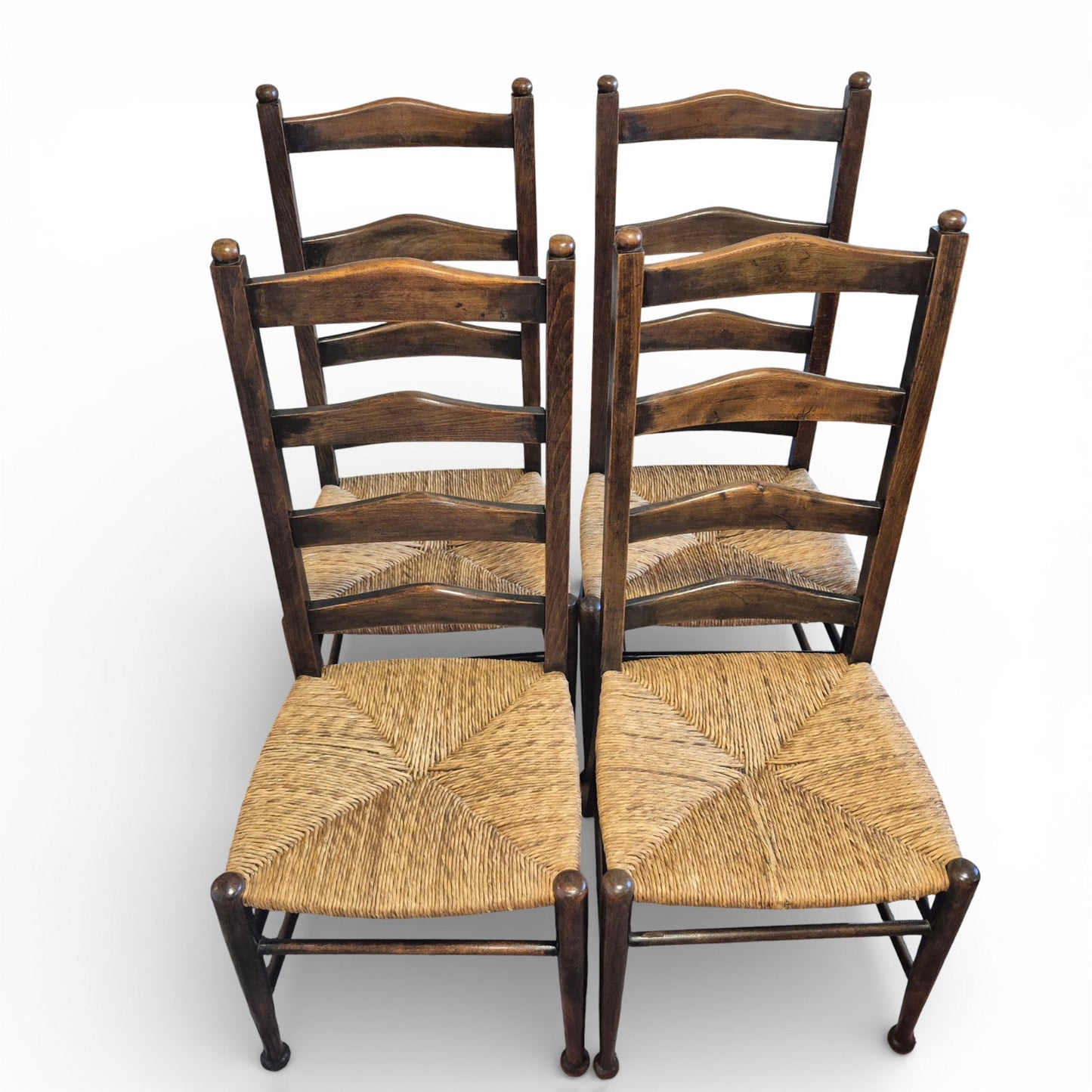 Front view of antique oak ladderback chairs with rush seats