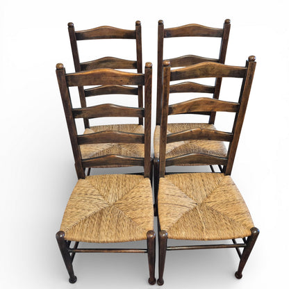 Front view of antique oak ladderback chairs with rush seats