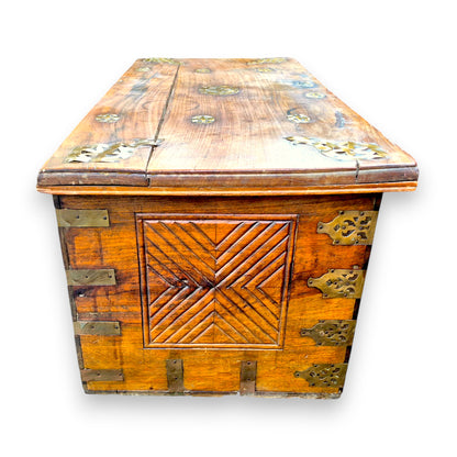 Side view of antique padouk chest showing geometric carved panel
