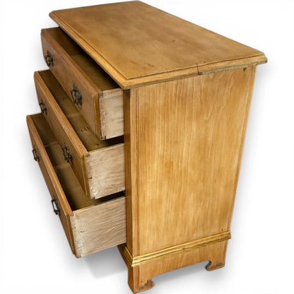 Three-quarter view of antique pine chest of drawers showing natural grain