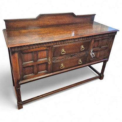 Antique Waring & Gillows oak sideboard with carved drawers and panelled doors