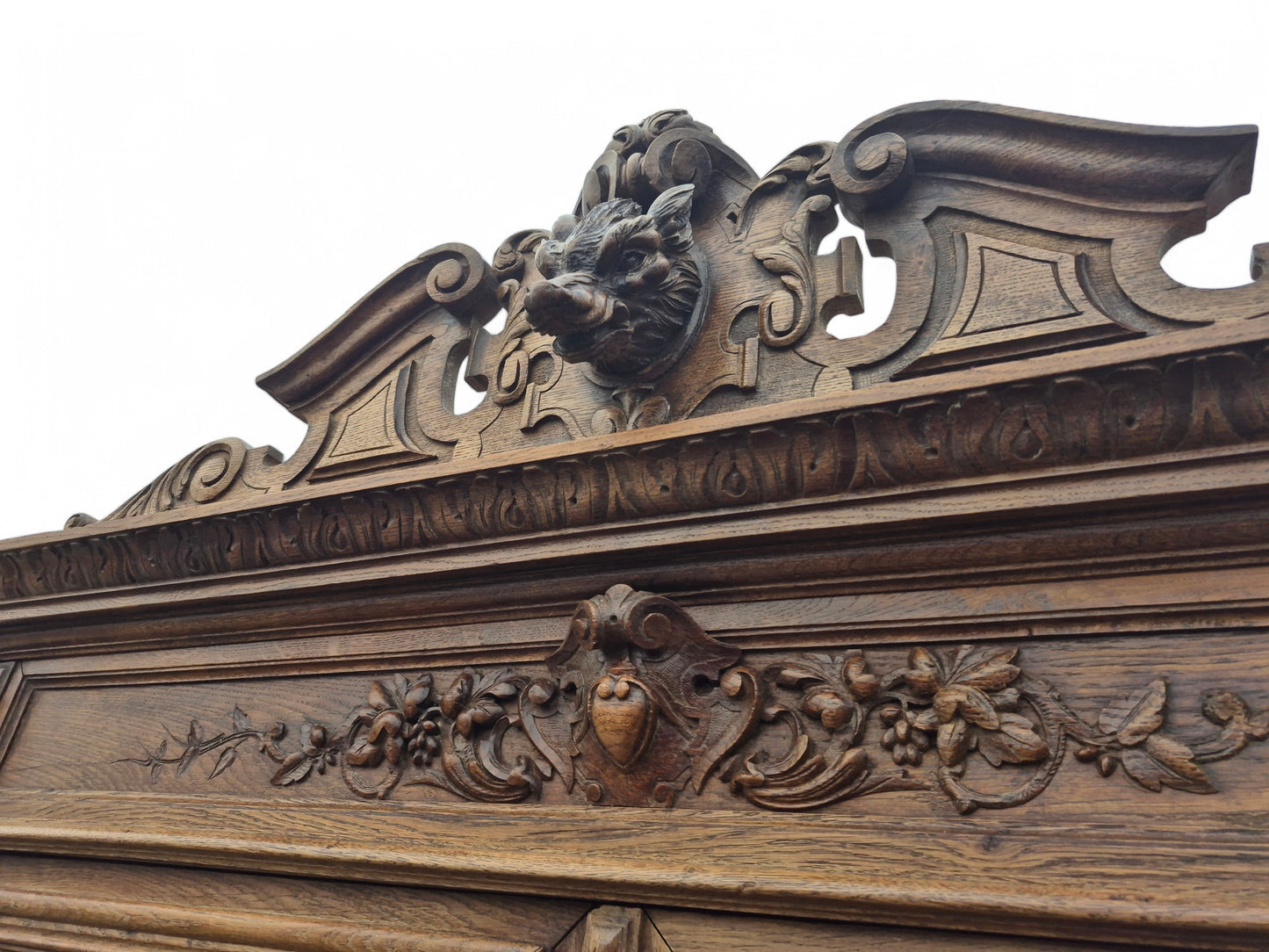 Close-up of carved boar’s head pediment on late 19th-century French oak dresser