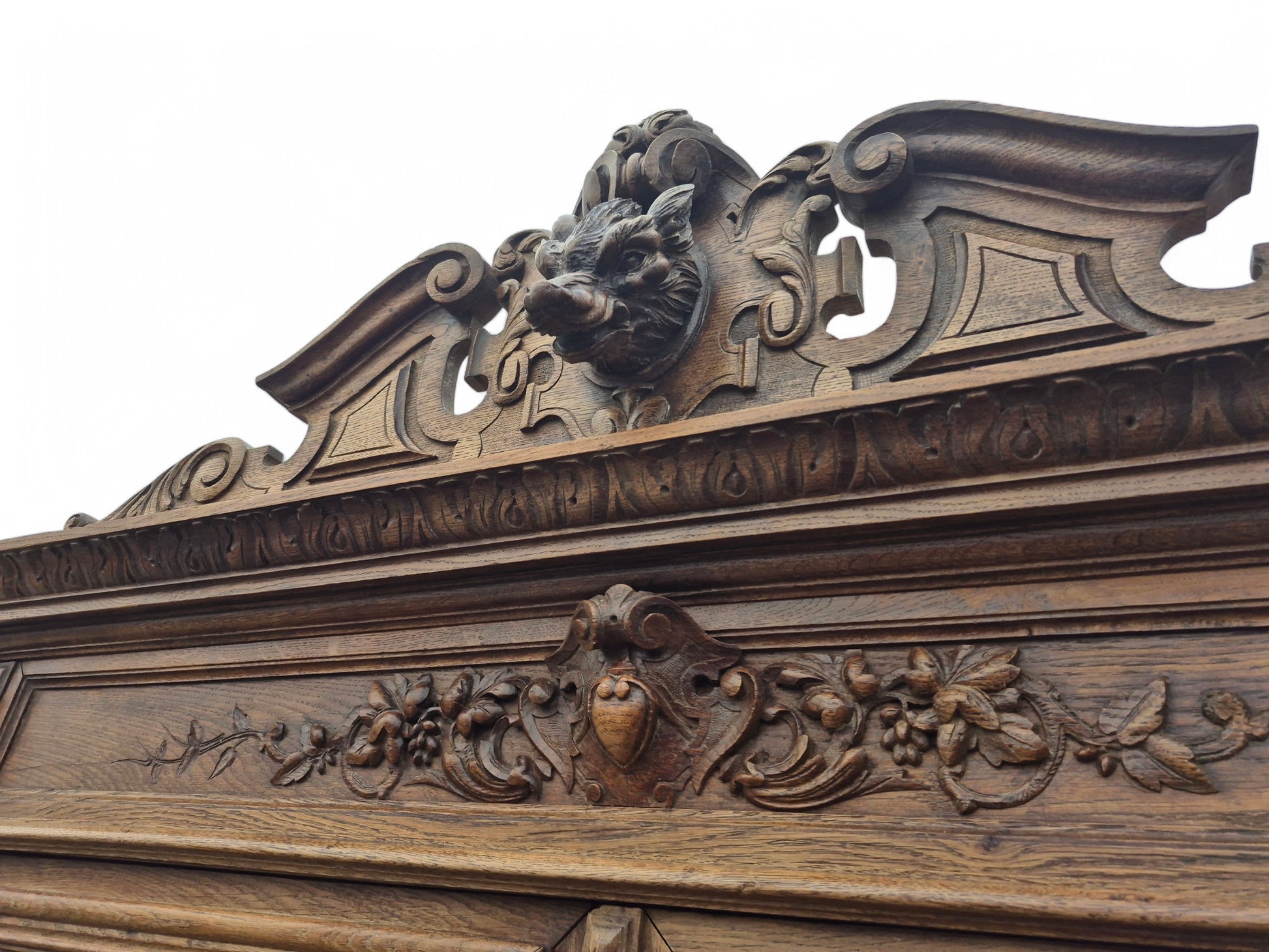 Close-up of carved boar’s head pediment on late 19th-century French oak dresser