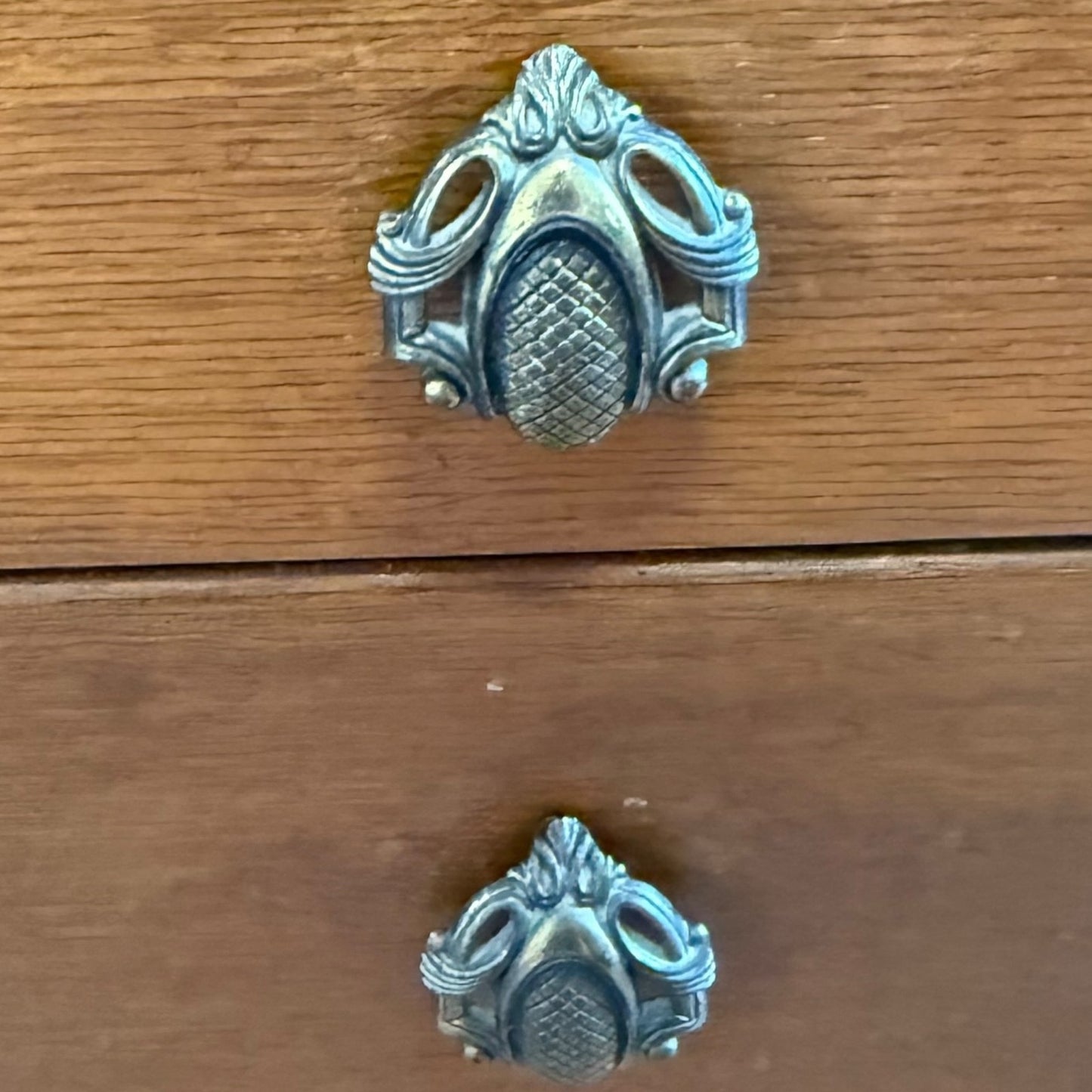 Close-up of ornate drawer handles on vintage oak vanity table