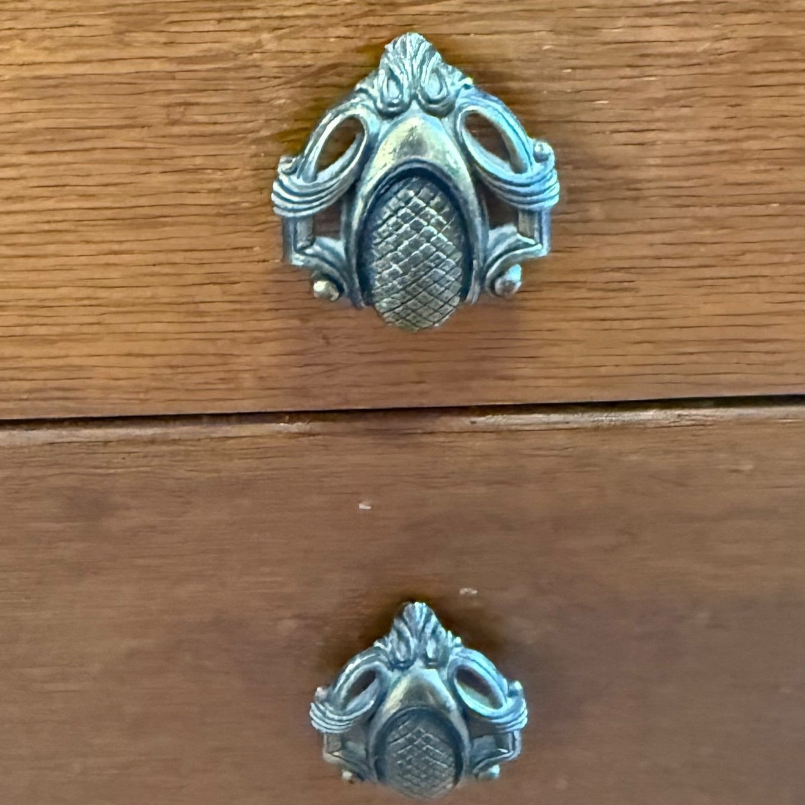 Close-up of ornate drawer handles on vintage oak vanity table