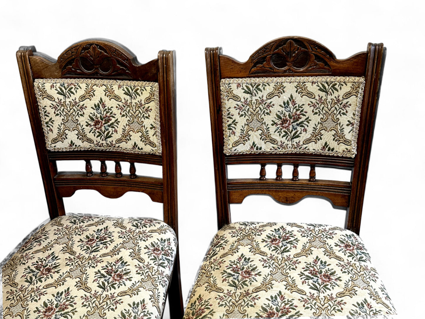Detail of cream upholstered seats on antique Edwardian mahogany chairs — fine stitching and warm wood grain.