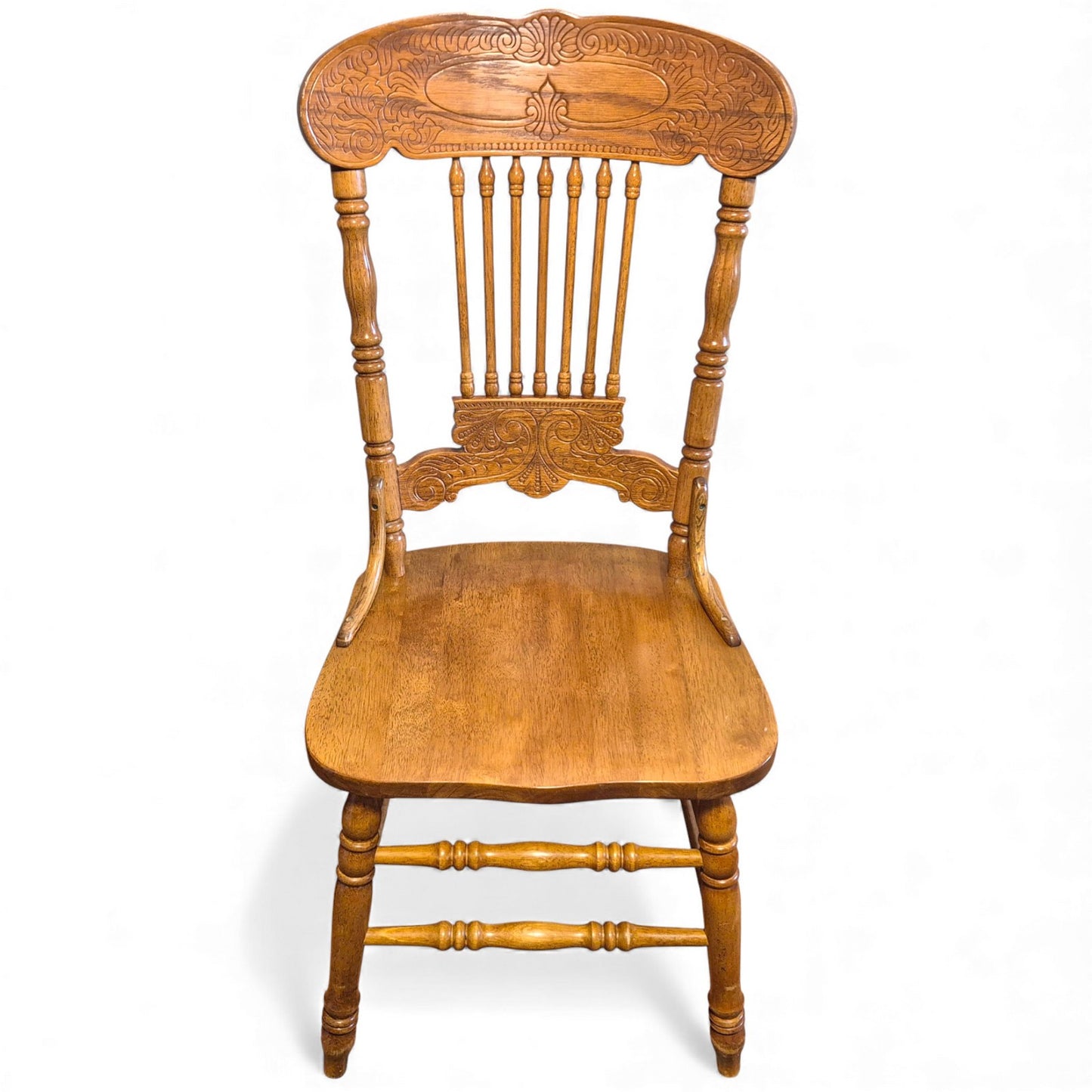 Oak dining chairs with spindle backs and carved crest rails