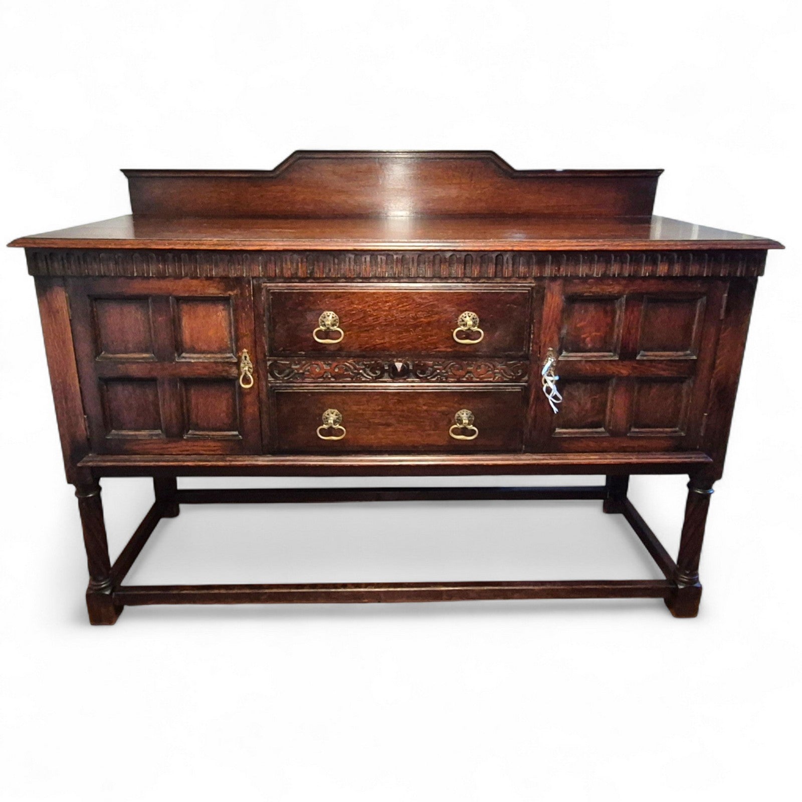 Front view of vintage oak sideboard showing storage drawers and cupboard doors
