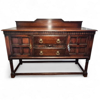 Front view of vintage oak sideboard showing storage drawers and cupboard doors