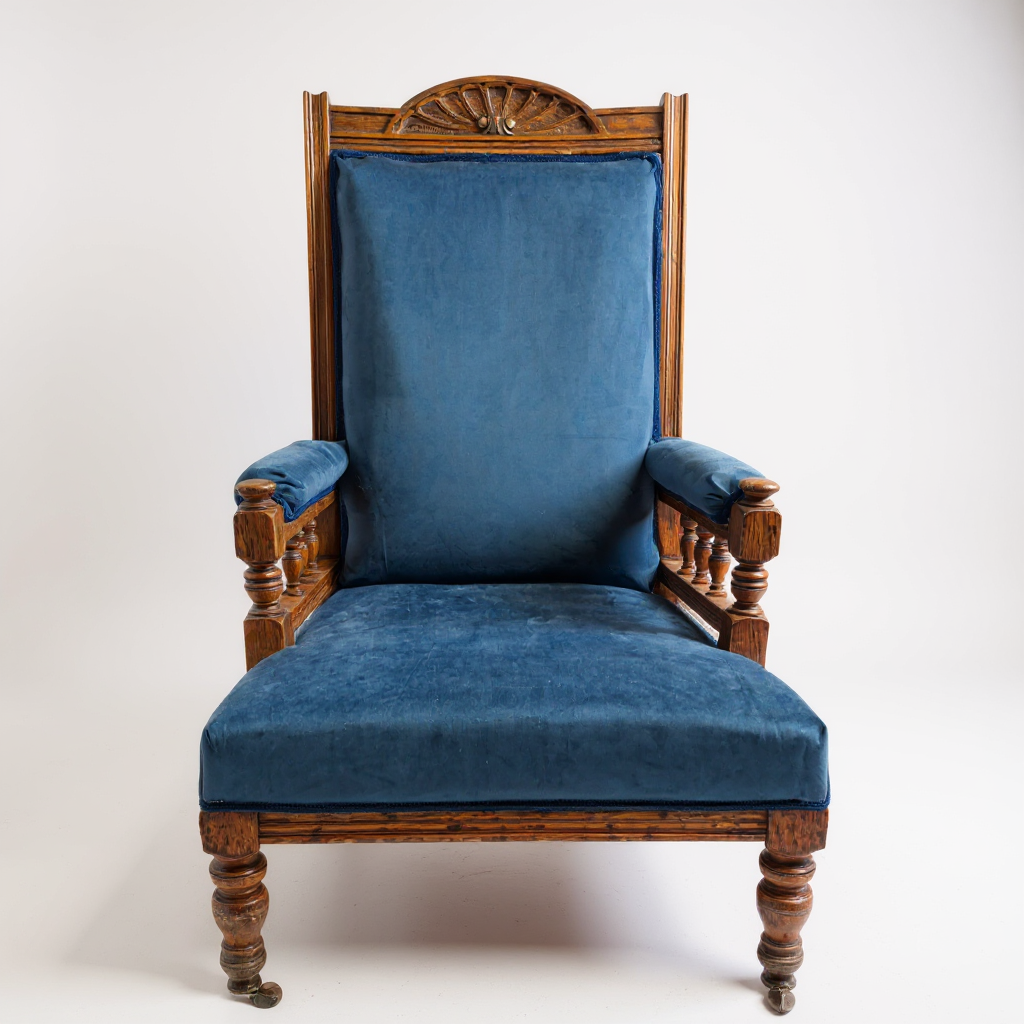 Front view of Victorian oak nursing chair with castor legs and upholstered seat