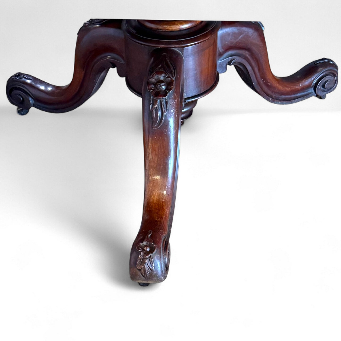 Ornate carved pedestal base on Victorian mahogany tilt-top table – antique craftsmanship detail