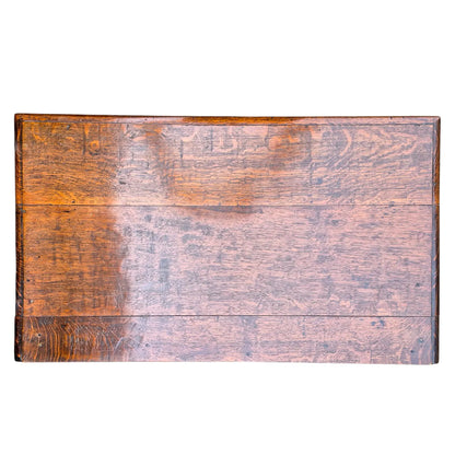 Plank top of antique oak side table showing natural wear, grain, and warm oak tone.