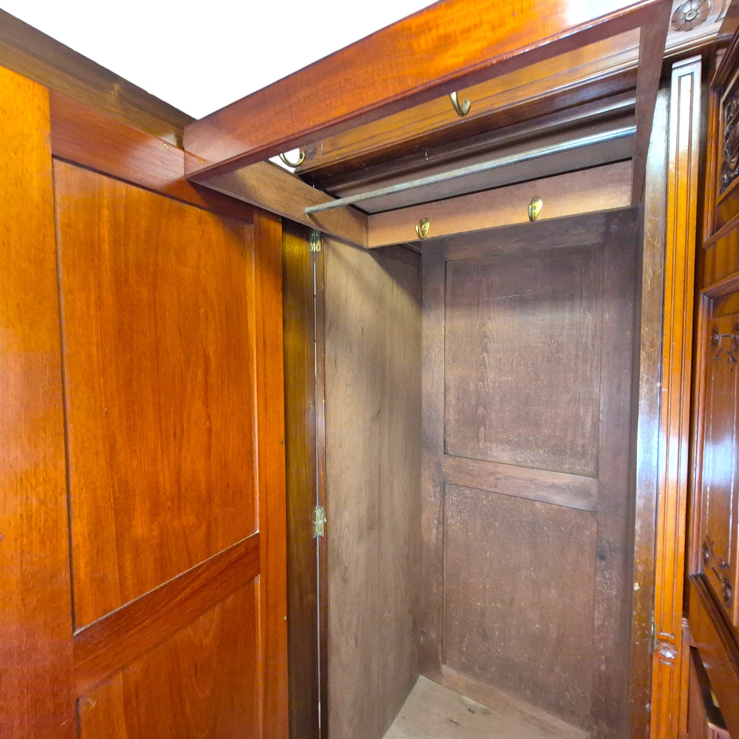 Victorian walnut compactum wardrobe staged in a neutral bedroom with mirror, drawers and carved panels