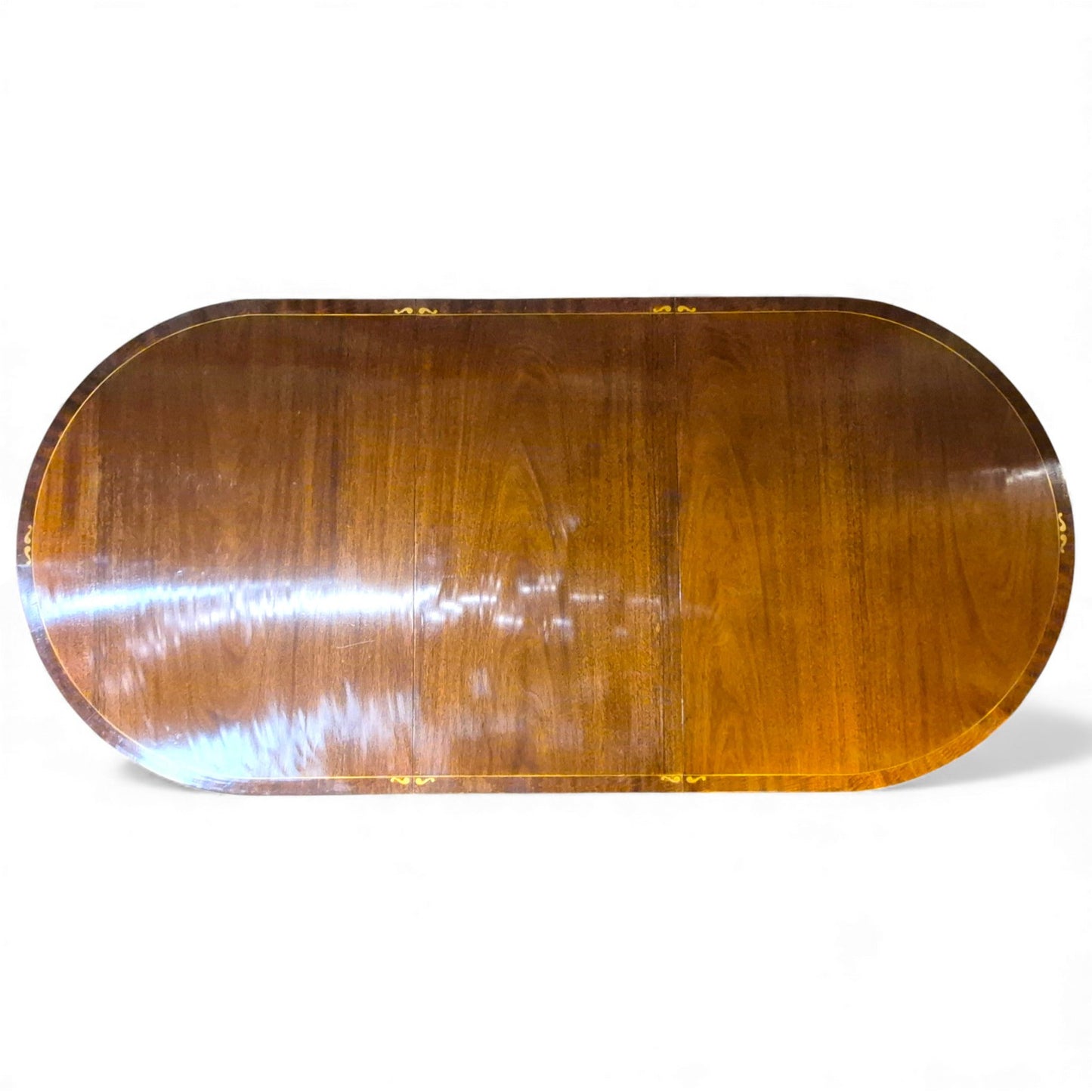 “Top-down view of Regency style mahogany dining table showing rich grain and brass inlay”