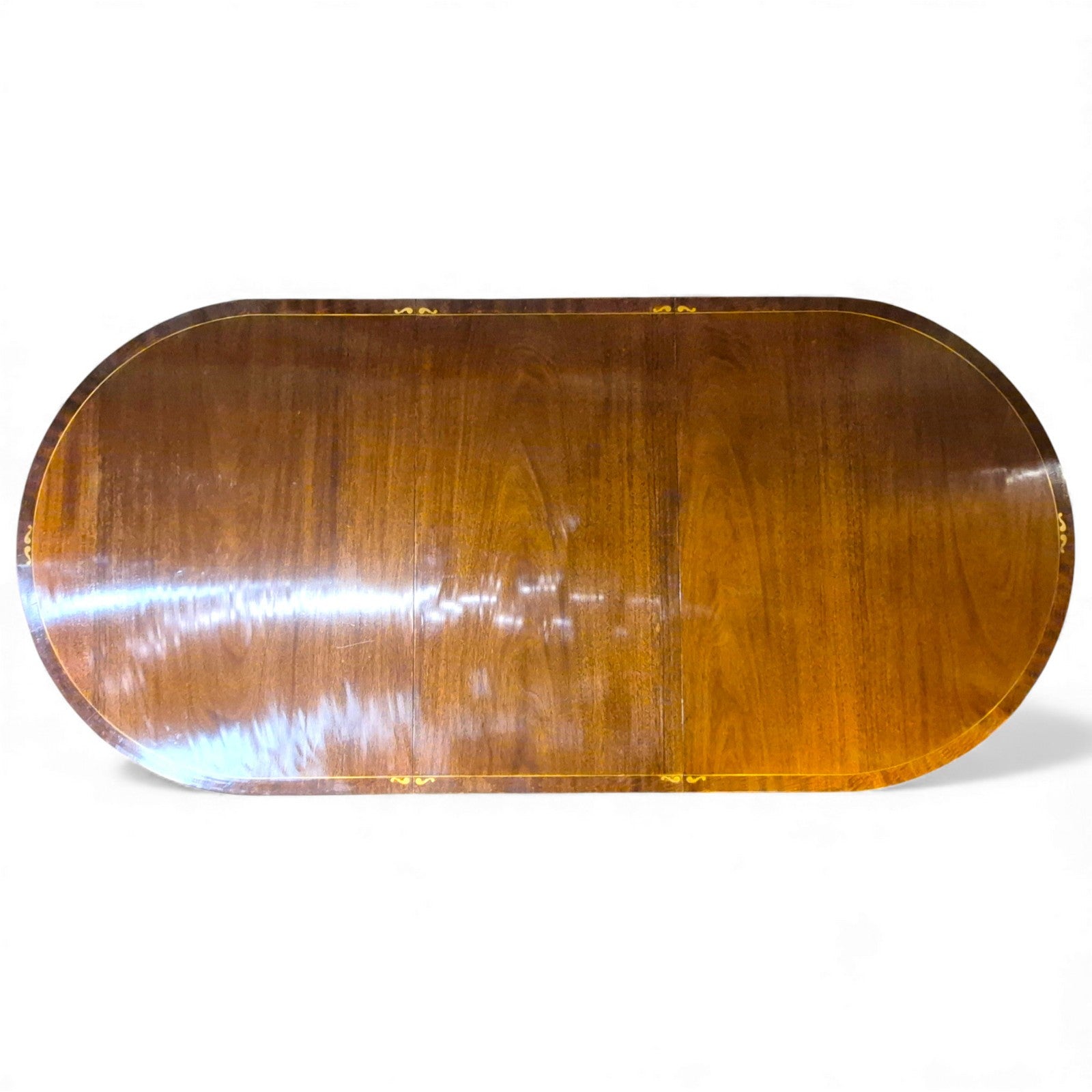 “Top-down view of Regency style mahogany dining table showing rich grain and brass inlay”