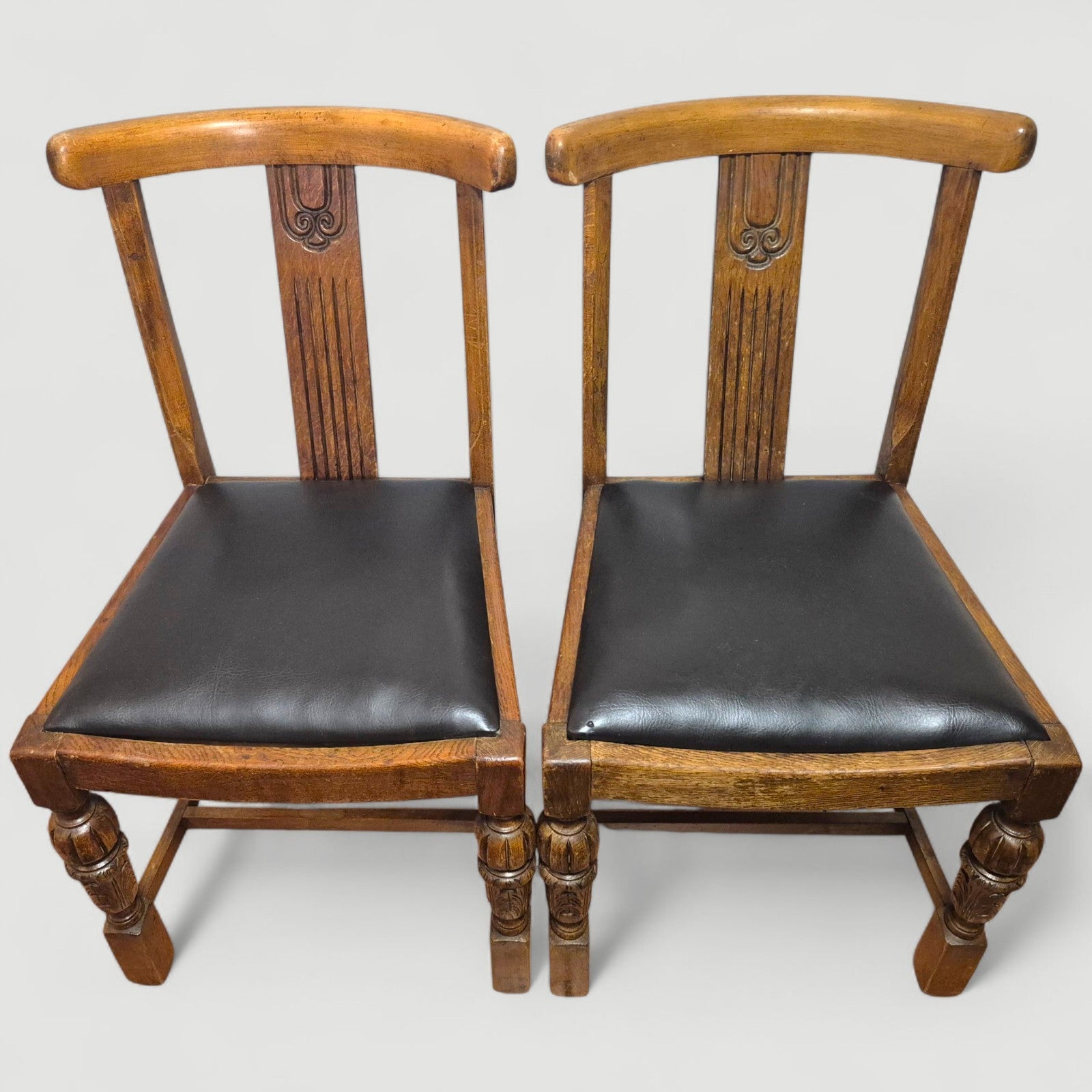 Carved back detail of 1920s honey oak dining chair showing fluted design
