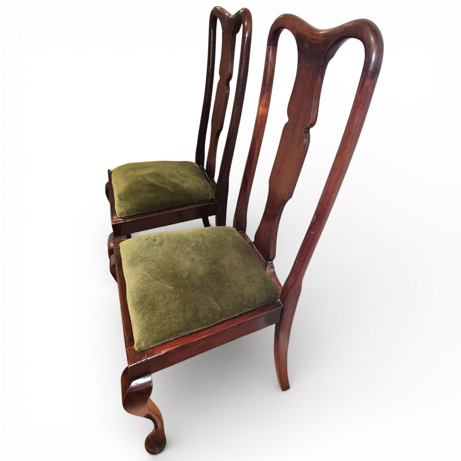 Angled view of Queen Anne style mahogany dining chairs showing high backs and cabriole legs