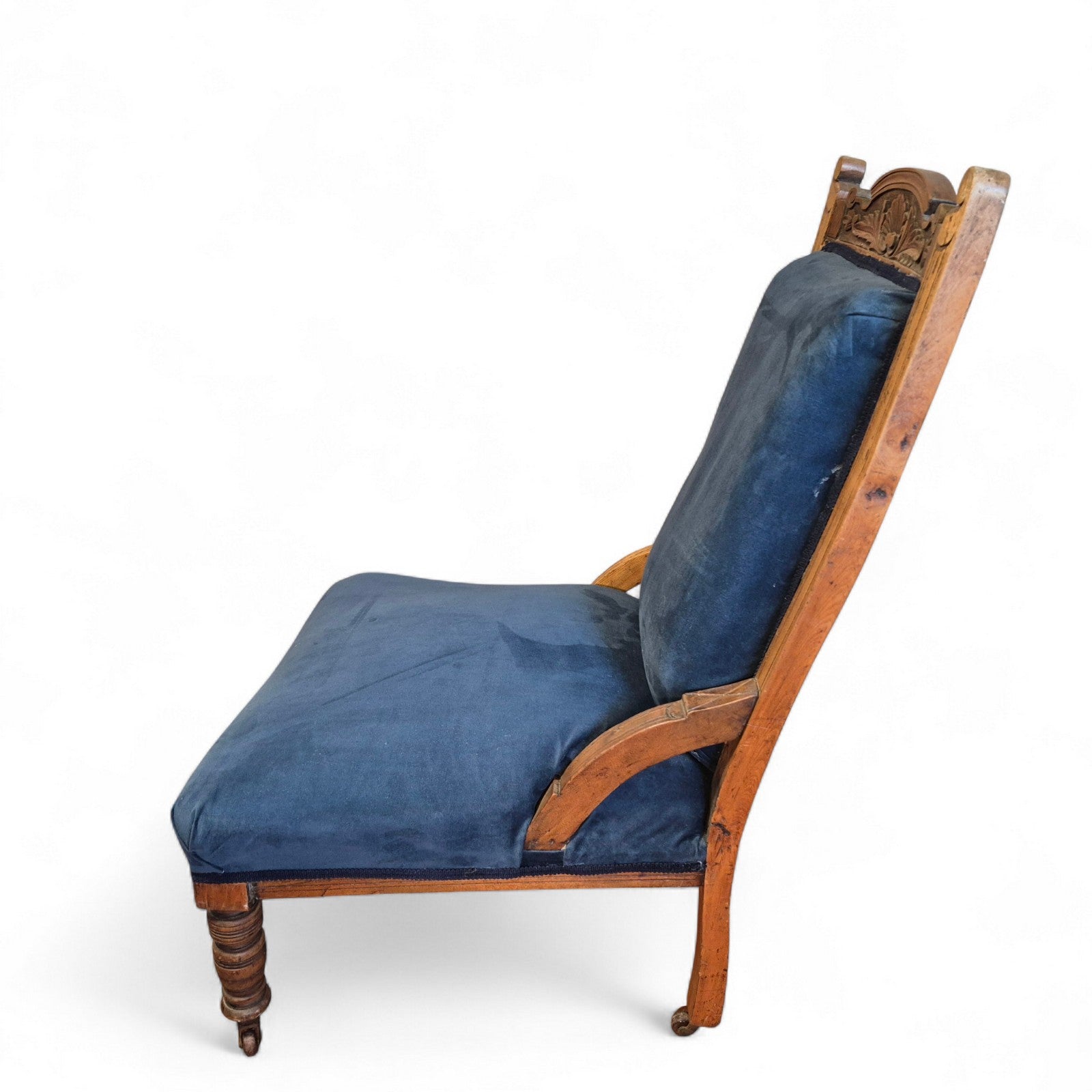 Side view of carved oak antique nursing chair with upholstered seat