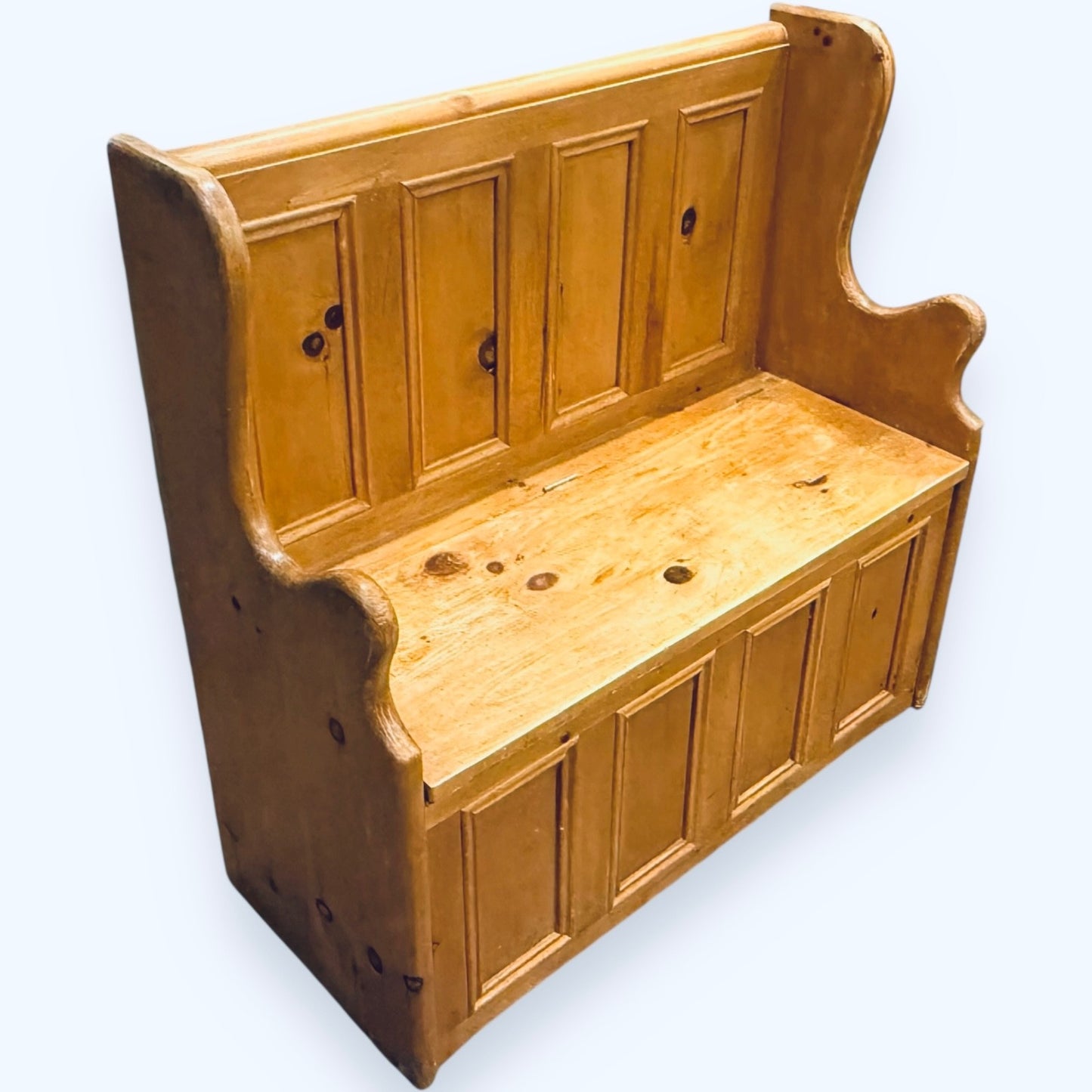 Side view of waxed pine monks bench with shaped arms and warm finish