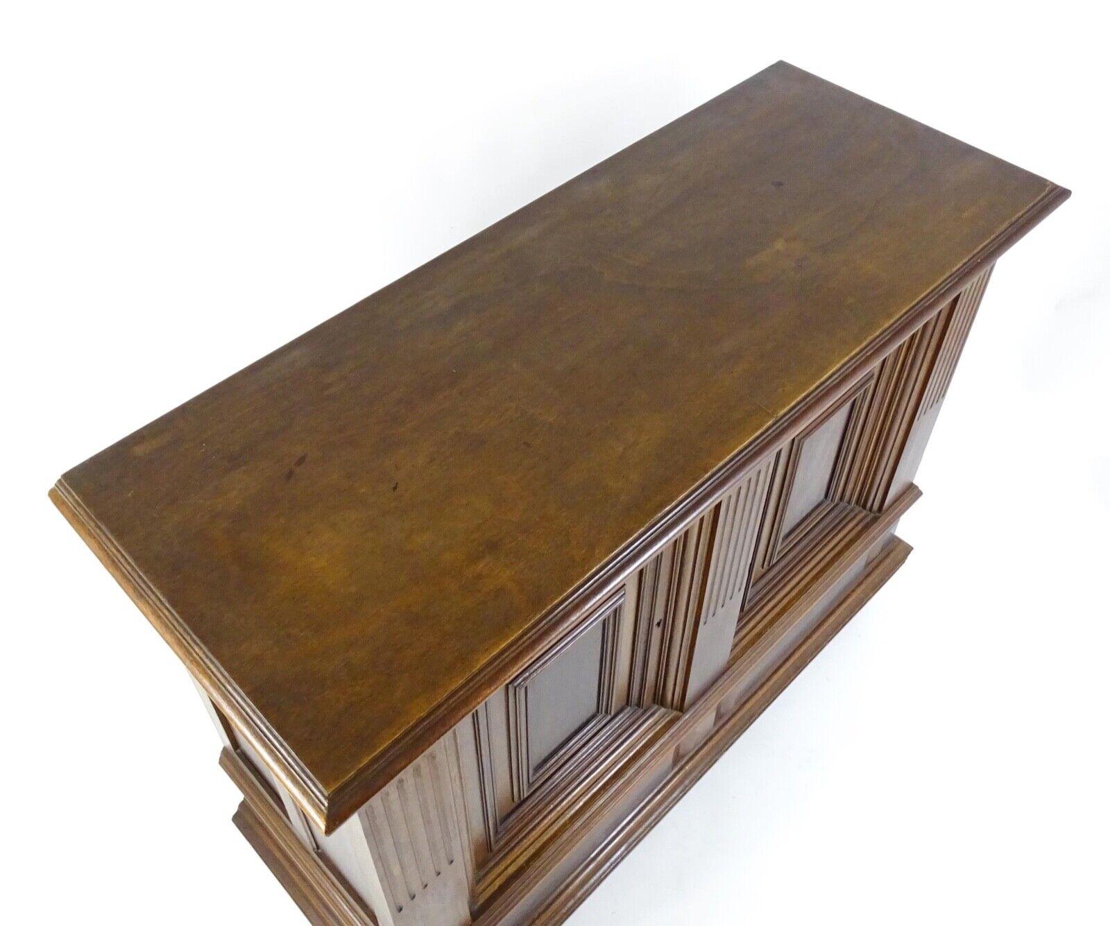 Top view of antique walnut cupboard with moulded top and storage drawer