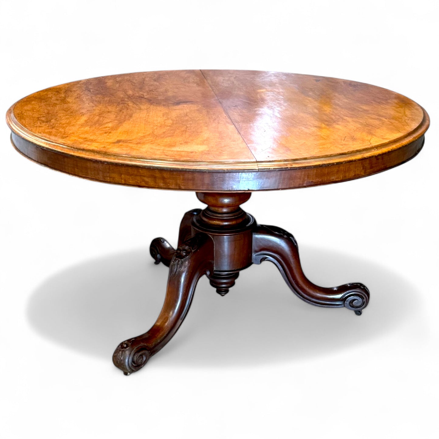 Close-up of round mahogany tabletop showing rich grain and warm tones – antique Victorian dining table
