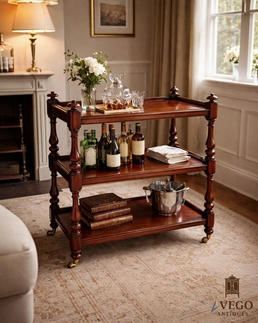 Victorian mahogany dumb waiter styled as drinks trolley with bottles and glassware in interior setting