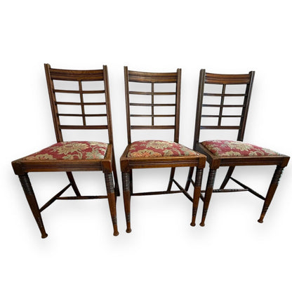 Front view of three Victorian mahogany ladderback dining chairs with floral upholstered seats – Arts & Crafts style