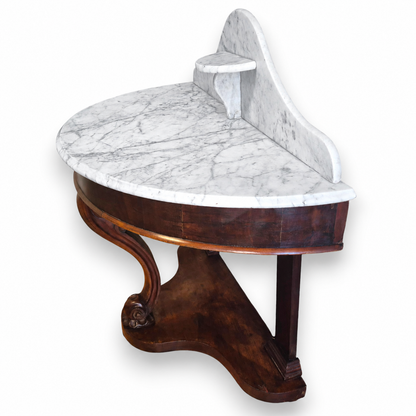 Side view of a Victorian mahogany washstand showing the curved frieze, marble backstand and shaped base.