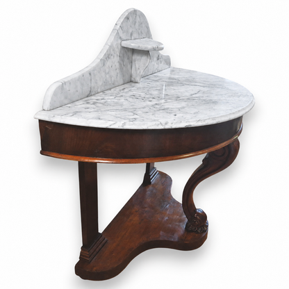 Side view of a Victorian mahogany console table showing the curved frieze, marble backstand and shaped base.
