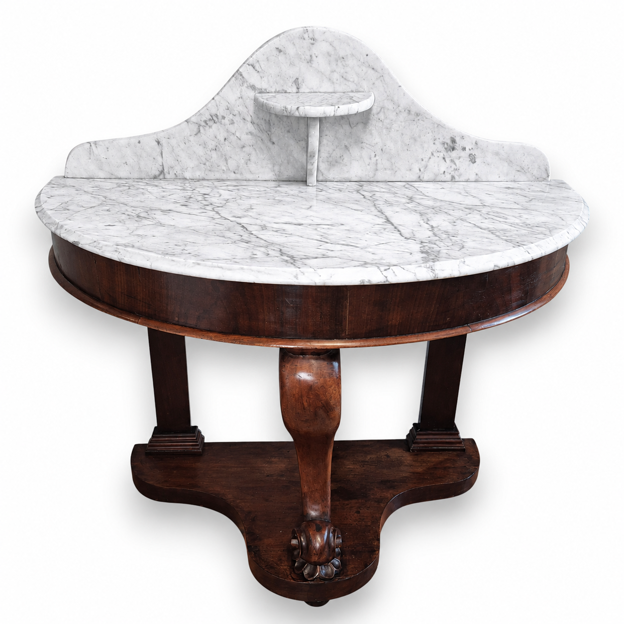 Front view of a Victorian mahogany washstand featuring a curved marble top and carved central support.