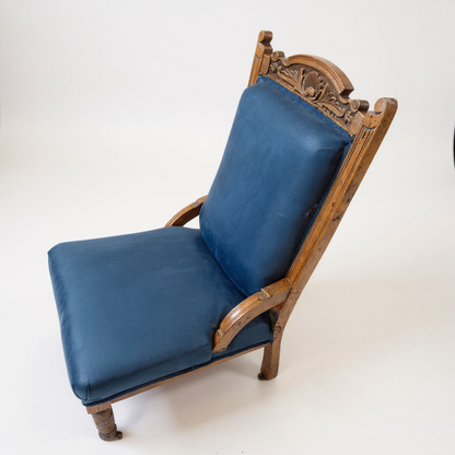 Angled view of carved oak antique nursing chair with upholstered seat