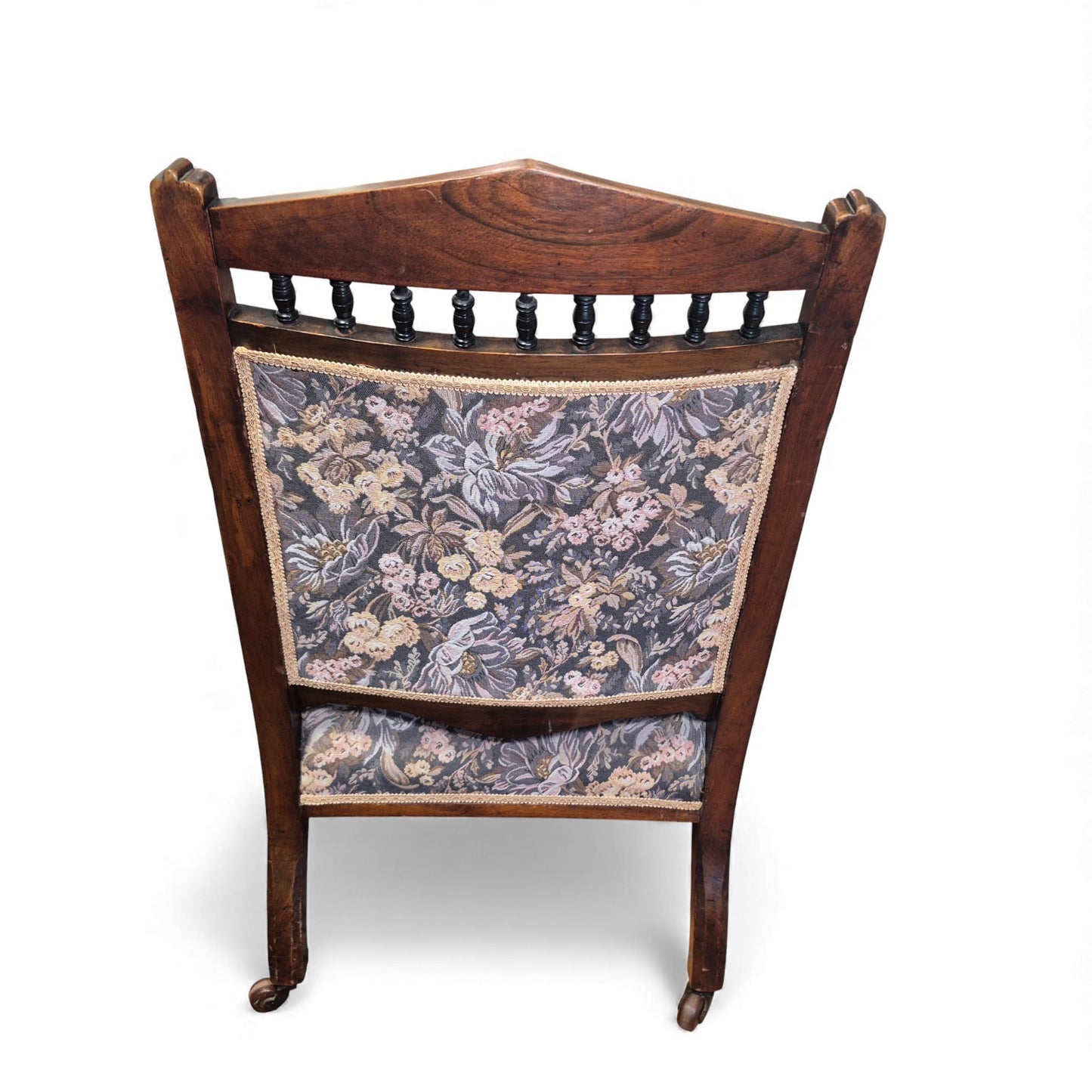 Back view of carved oak nursing chair with spindle gallery
