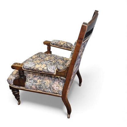 2nd Side view of Victorian oak nursing chair showing turned arm supports and castors